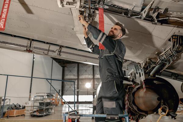 cheerful-male-mechanic-repairing-aircraft-at-repair-station-photo cheerful-male-mechanic-repairing-aircraft-at-repair-station-photo